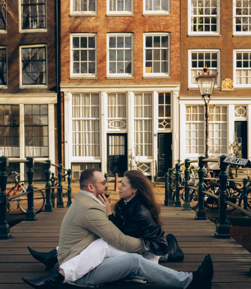 Couple sitting together on a wooden canal bridge, Amsterdam