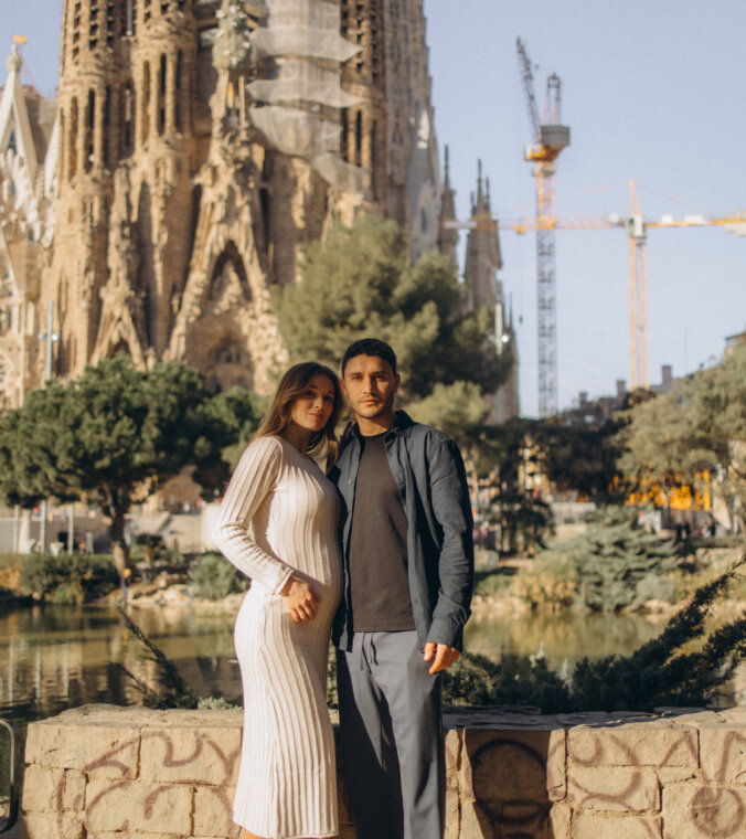 Couple standing together in Plaça de Gaudí with the Sagrada Familia towers behind, Barcelona
