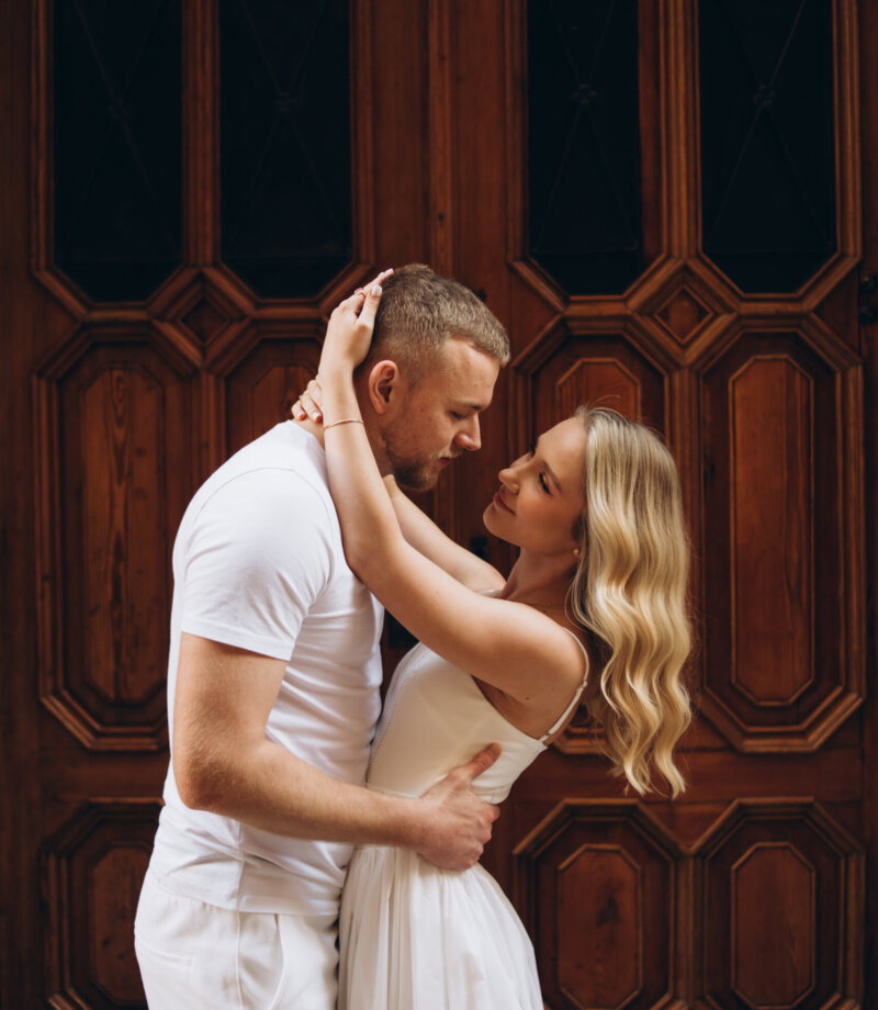 Couple in white embracing against a carved wooden door in the Gothic Quarter, Barcelona