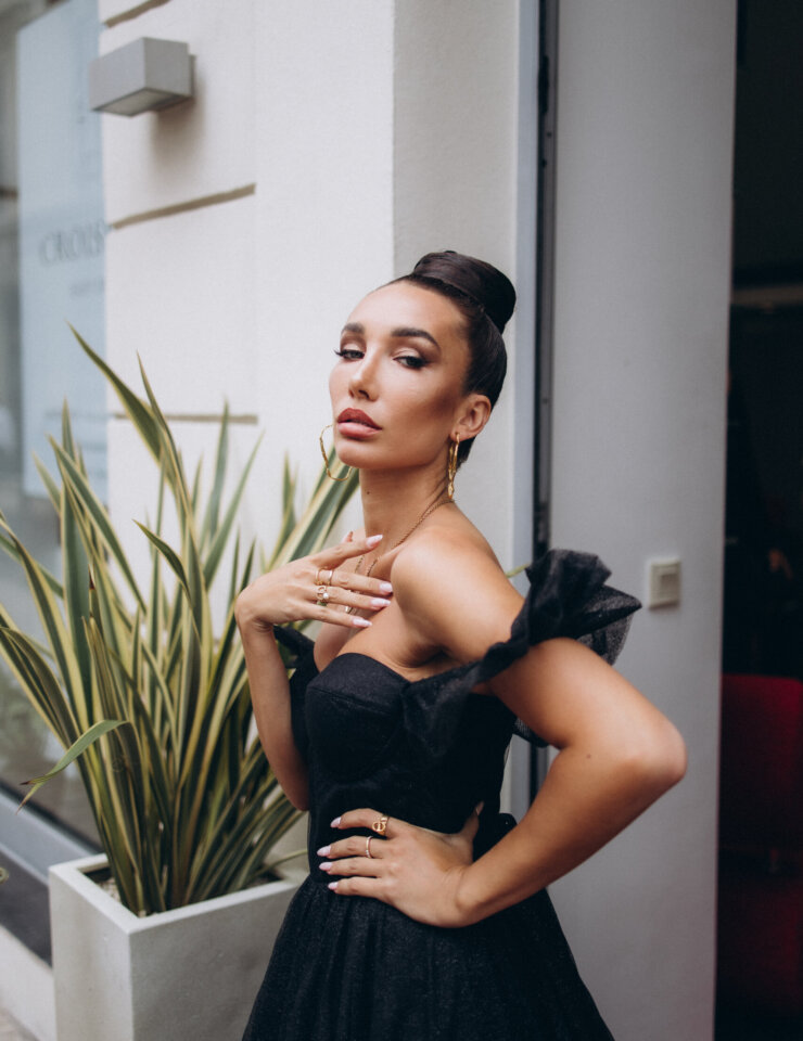 Woman in a black off-shoulder gown posing at a hotel entrance on La Croisette, Cannes