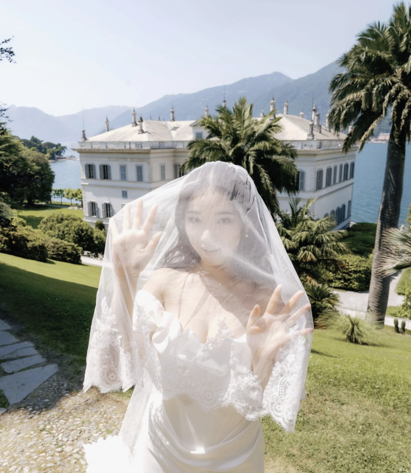 Bride under a sheer veil in the gardens of Villa Melzi with palms behind, Lake Como