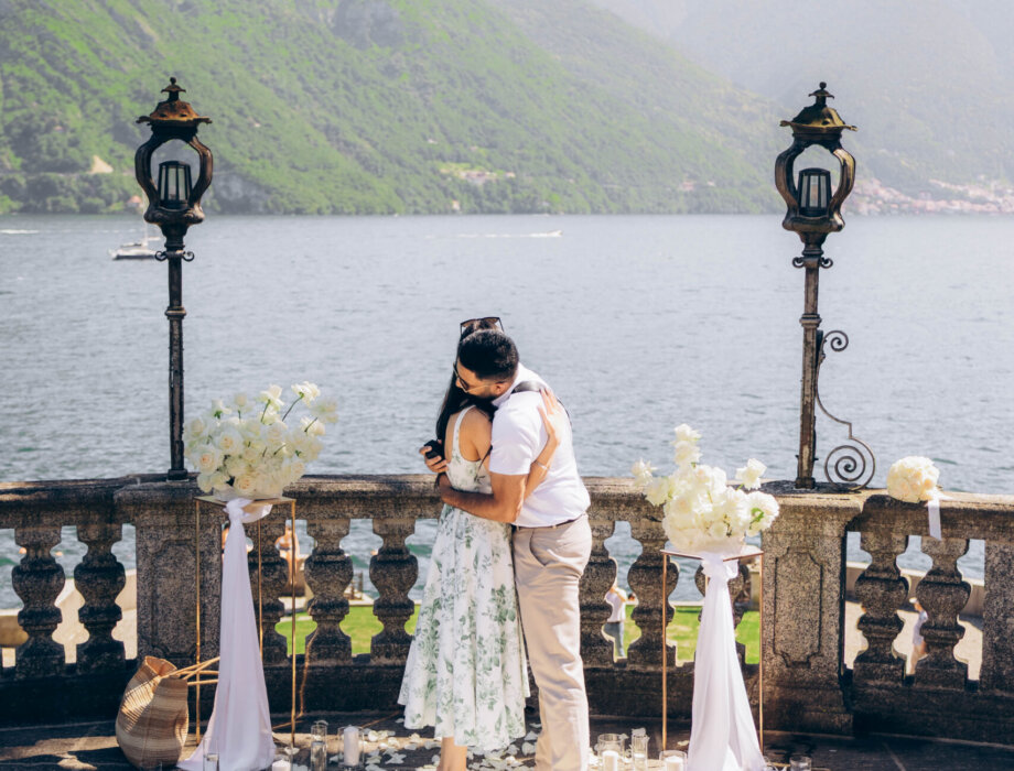 Newly engaged couple hugging on the petal-strewn terrace in Tremezzo, Lake Como