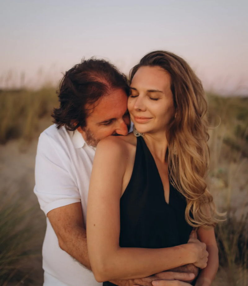Man embracing his partner in the golden dunes of Costa da Caparica, near Lisbon
