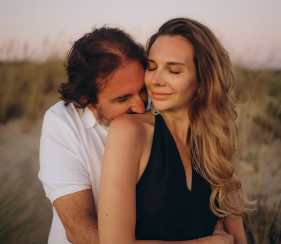 Man embracing his partner in the golden dunes of Costa da Caparica, near Lisbon
