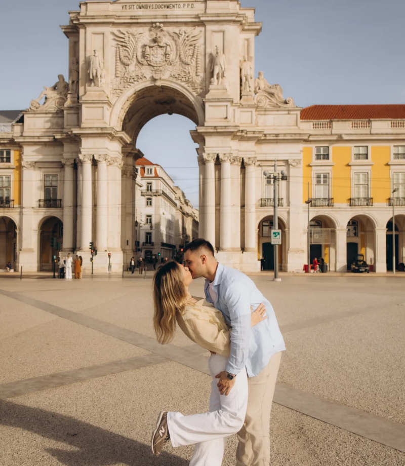 Couple dipping into a kiss in front of the Rua Augusta Arch, Lisbon