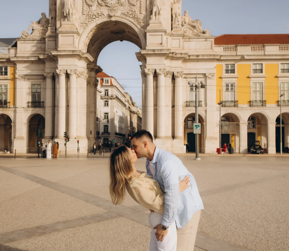 Couple dipping into a kiss in front of the Rua Augusta Arch, Lisbon