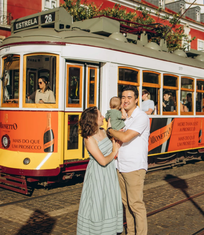 Family with a baby in front of tram 28, Lisbon