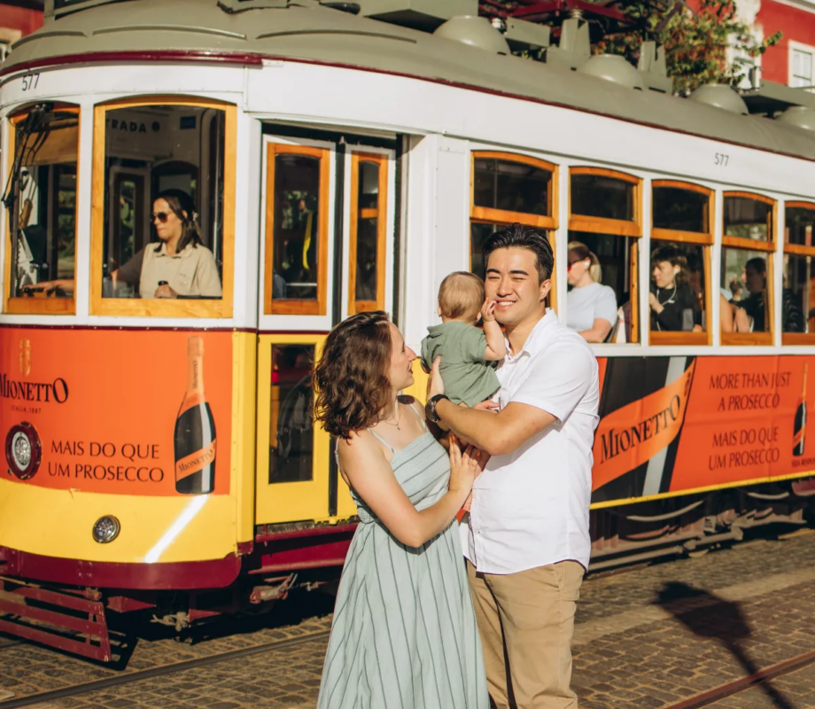 Family with a baby in front of tram 28, Lisbon