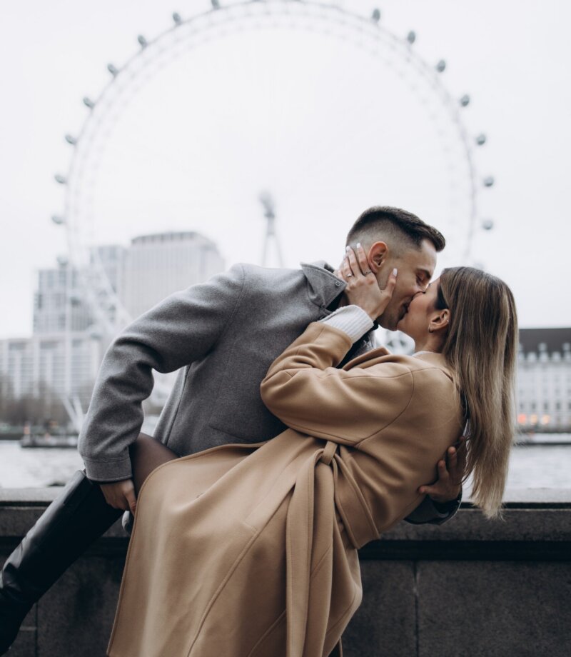 Man dipping his partner for a kiss on the Victoria Embankment, London Eye across the Thames