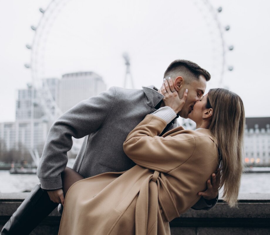 Man dipping his partner for a kiss on the Victoria Embankment, London Eye across the Thames