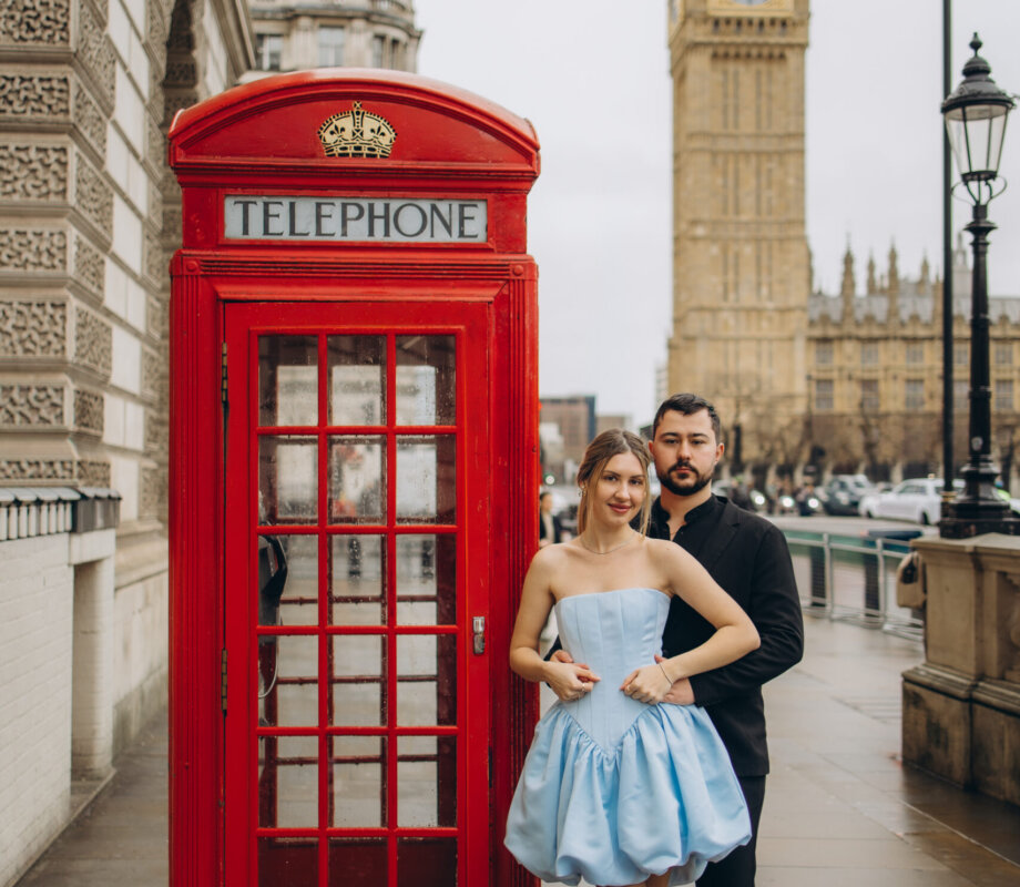 Couple beside a red telephone box with Big Ben behind, she in a pale blue dress, London