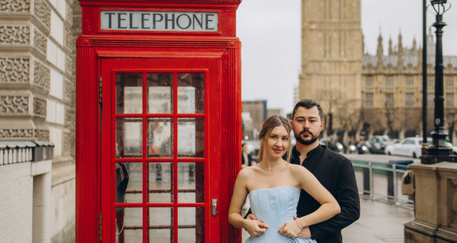 Couple beside a red telephone box with Big Ben behind, she in a pale blue dress, London