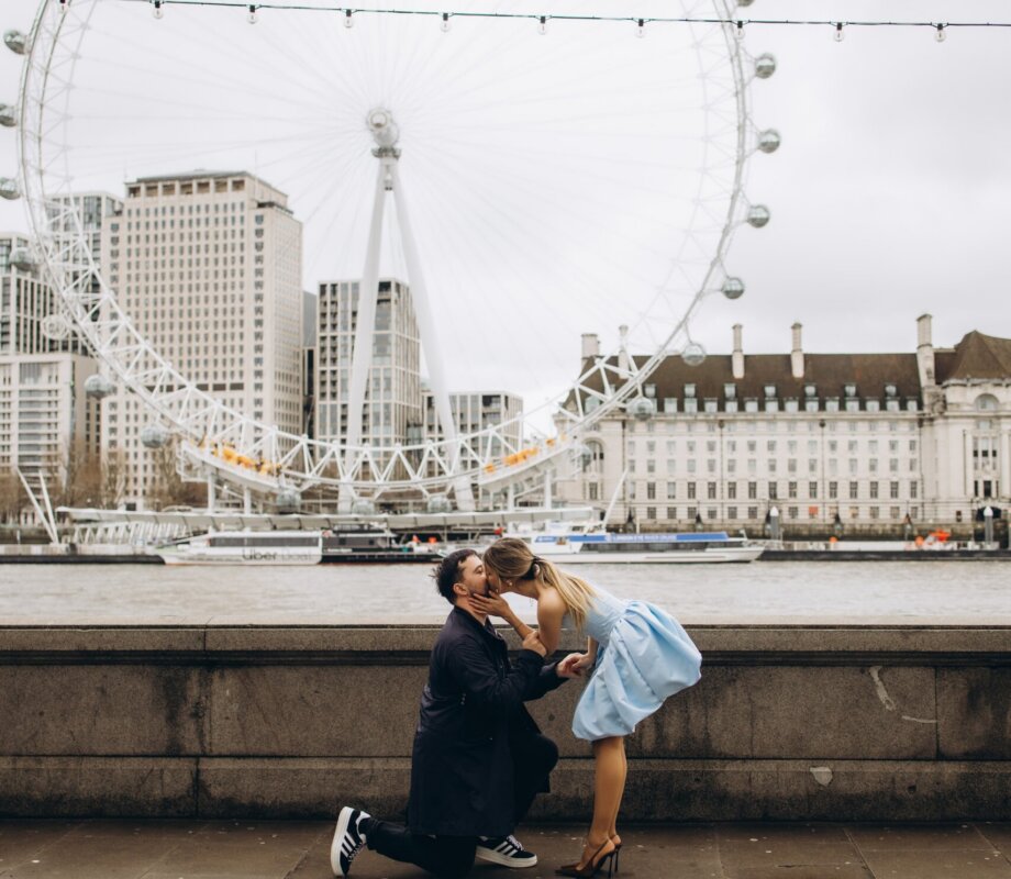 Couple kissing after the proposal on the Victoria Embankment, London Eye across the Thames