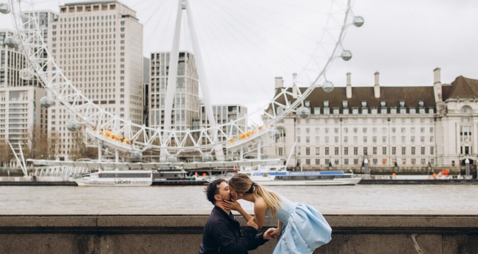 Couple kissing after the proposal on the Victoria Embankment, London Eye across the Thames