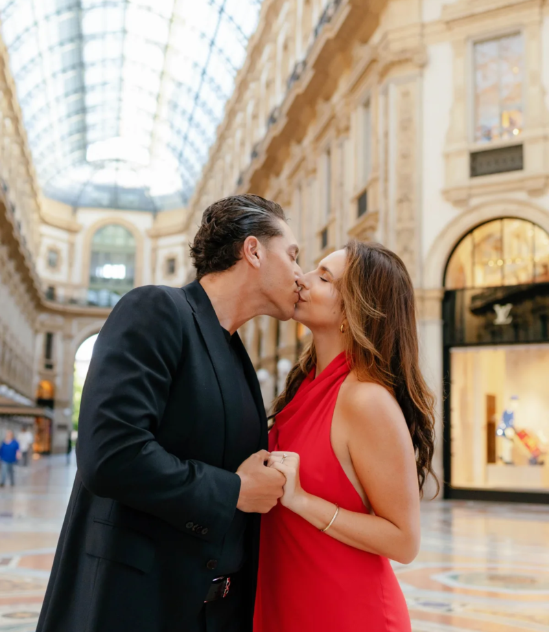Couple kissing under the long glass roof of the Galleria Vittorio Emanuele II, Milan