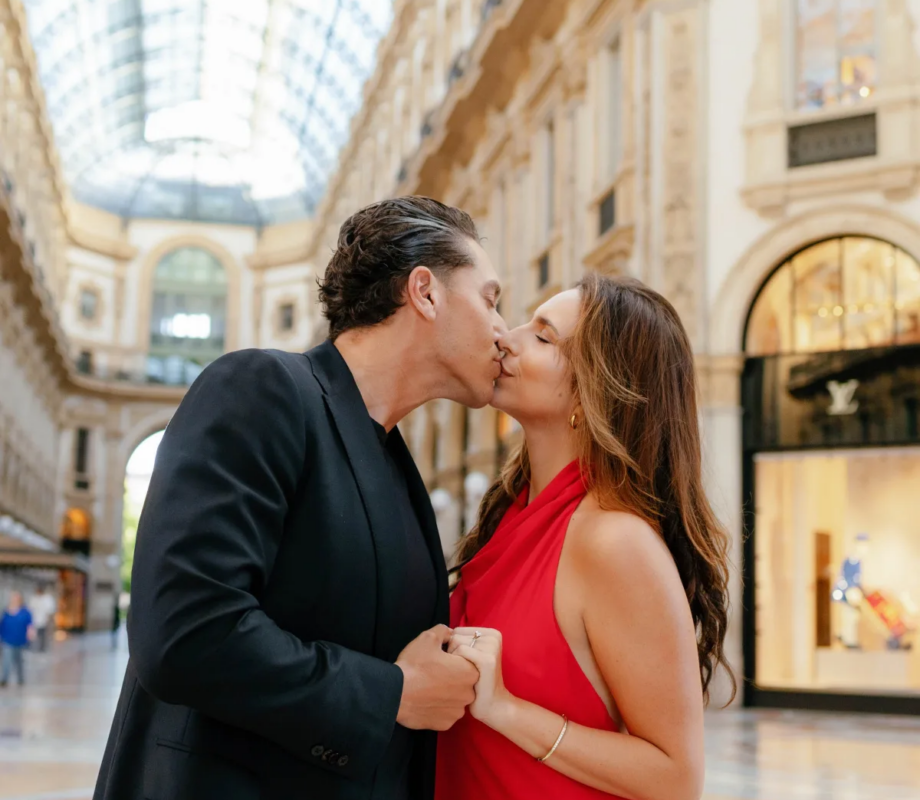 Couple kissing under the long glass roof of the Galleria Vittorio Emanuele II, Milan