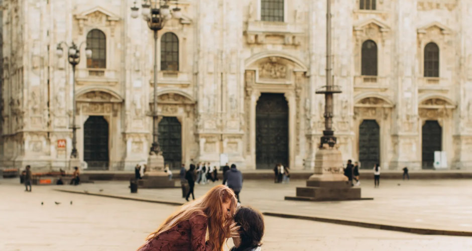 She hugs him as he kneels to propose on an empty Piazza del Duomo, Milan