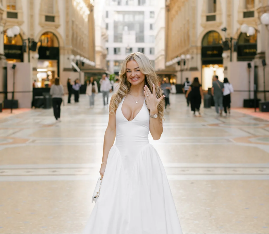 Woman in a white dress showing her ring under the great arch of the Galleria, Milan