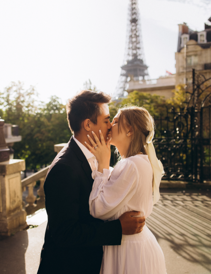 Engaged couple kissing at Avenue de Camoens with the Eiffel Tower in golden light, Paris