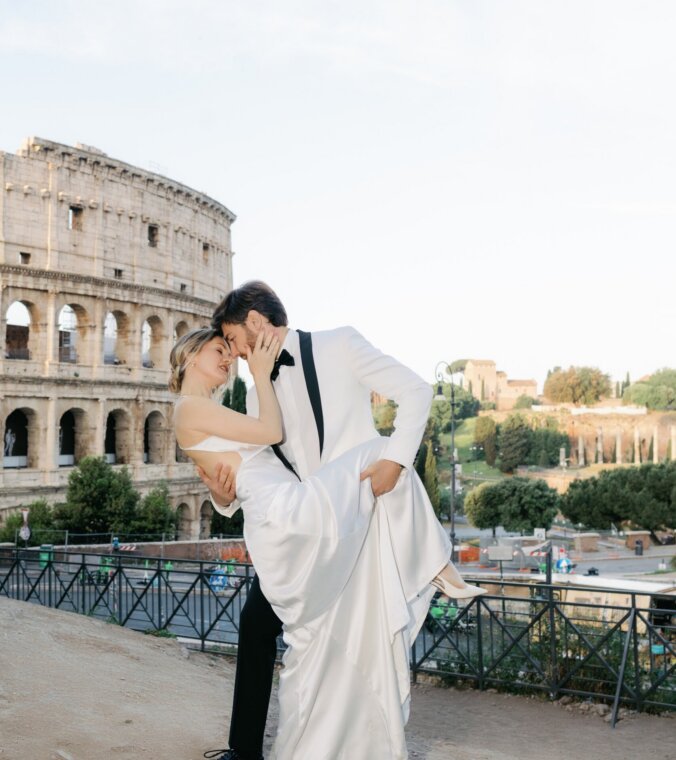 Couple dipping into a kiss on the terrace by the Colosseum on a May morning, Rome