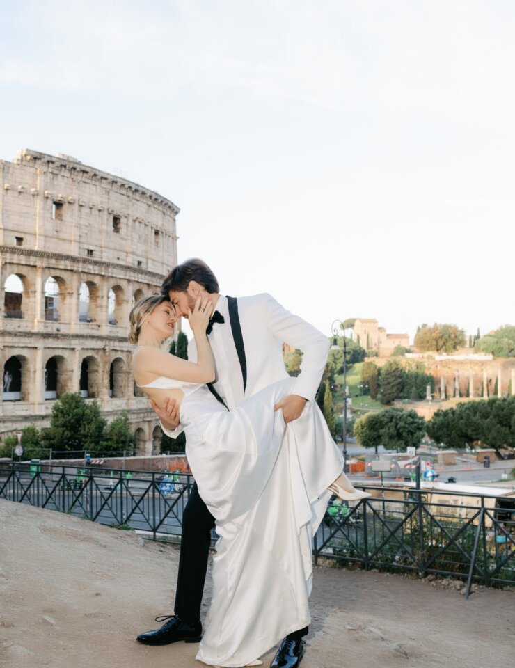 Couple dipping into a kiss on the terrace by the Colosseum on a May morning, Rome