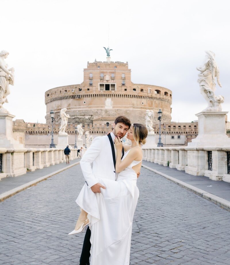 Groom lifting the bride on Ponte Sant'Angelo with the castle behind, Rome