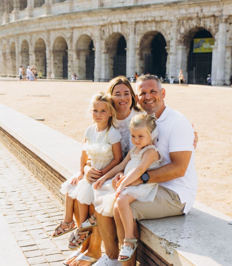 Family with two daughters at the Colosseum on a summer morning, Rome