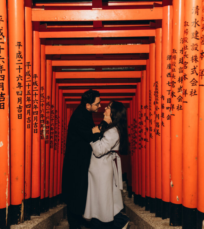 Couple kissing on the steps of the red torii gate tunnel at Hie Shrine in Akasaka, Tokyo