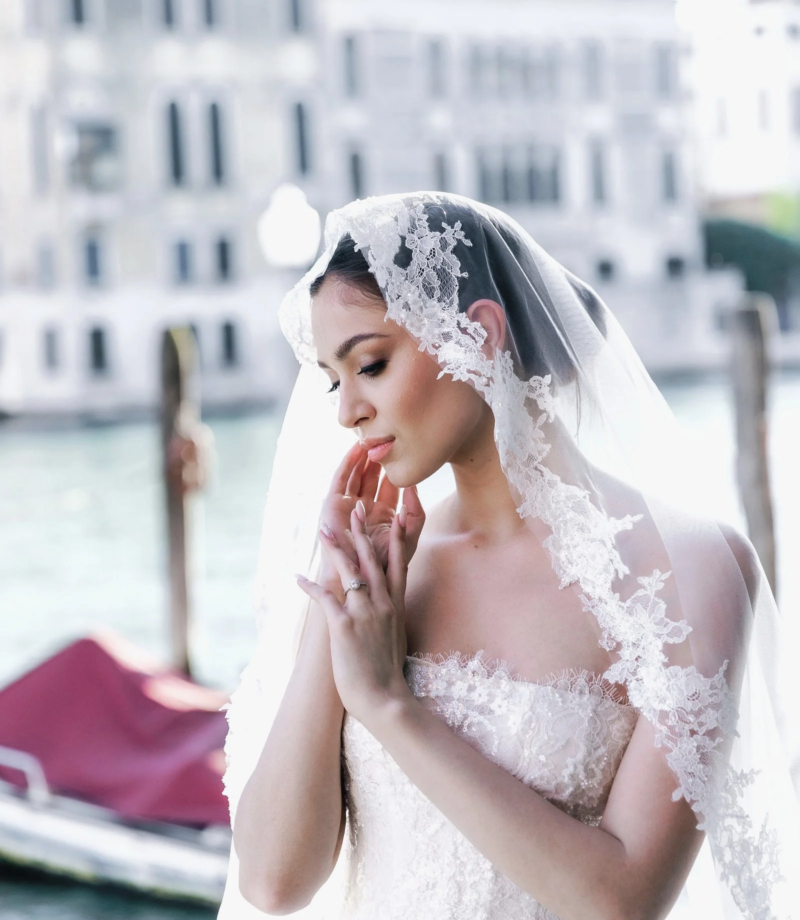 Bride in a lace veil by a canal, Venice