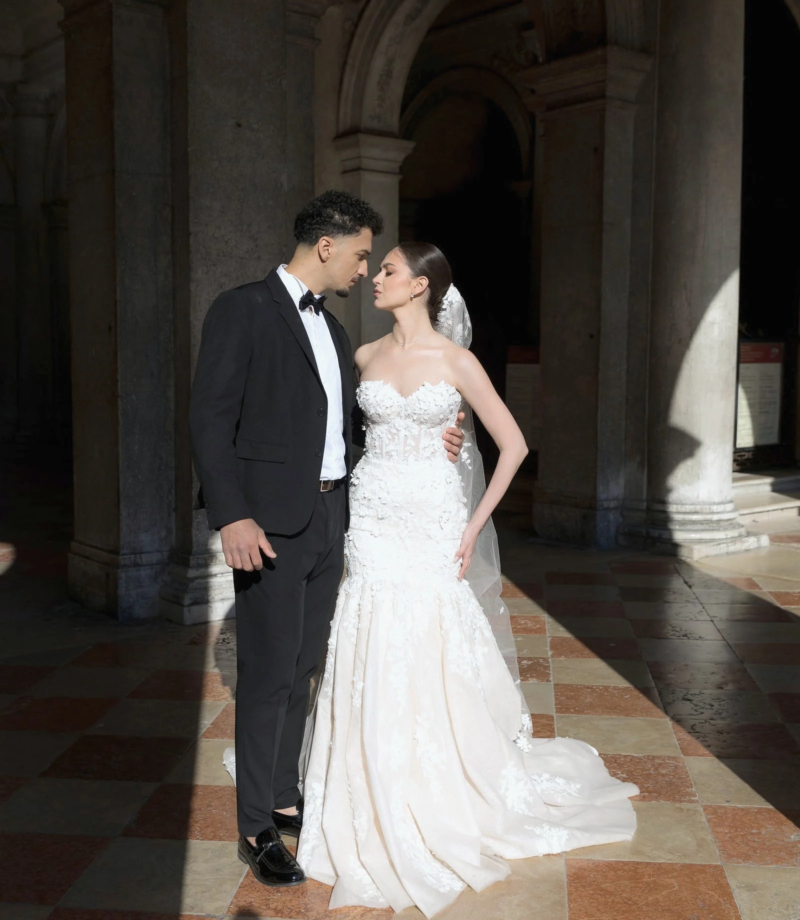 Bride and groom in a stone portico with a checkered floor, Venice