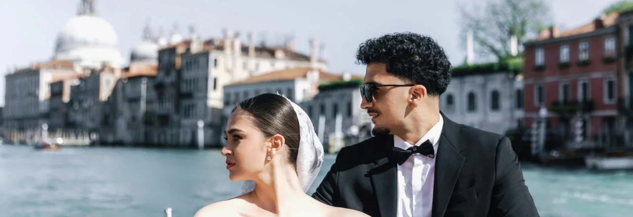 Bride and groom on a water taxi passing Santa Maria della Salute, Venice